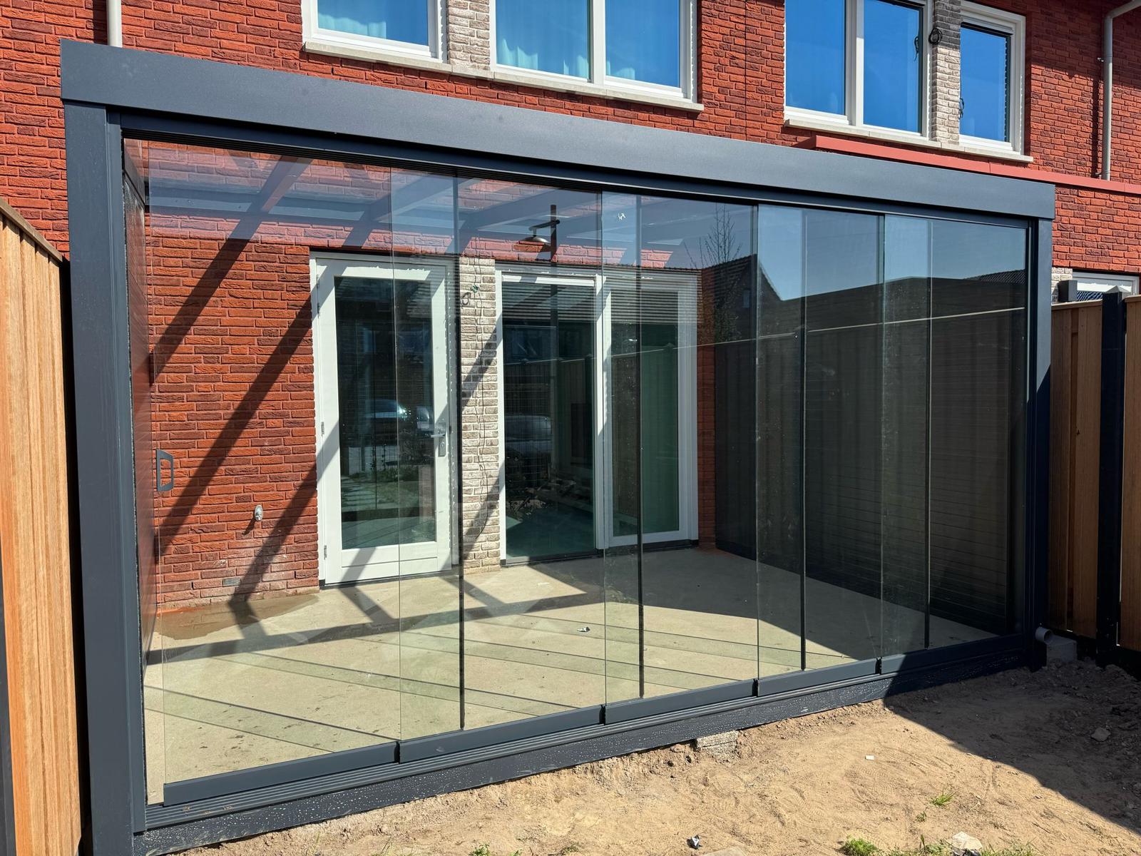 Moderne aluminium veranda met deels open zijwand en grote schuifpui